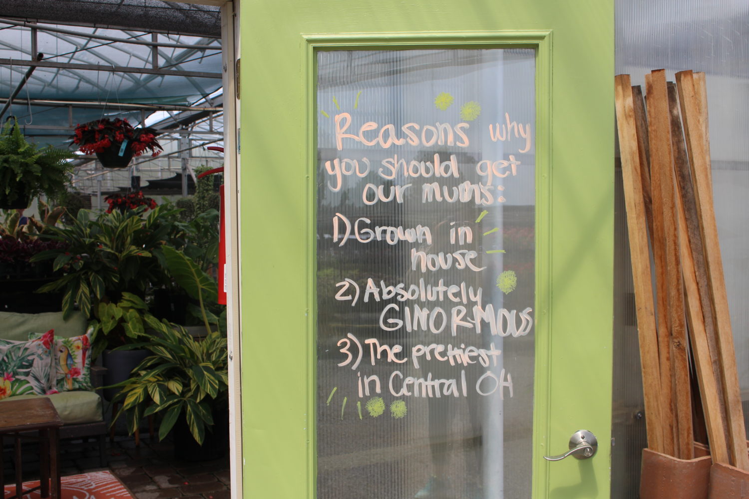 Hand-written signs on the doors remind customers of store hours and to return to purchase fall mums.